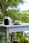 Jar of compote and tableware on a garden table