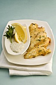 Catfish fillets in herb coating with parsley sauce
