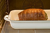 Roast pork in a roasting dish in the oven