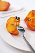 Persimmon wedge speared on fork
