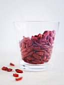 Goji berries in and beside glass