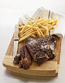 Beefsteak and chips on wooden board