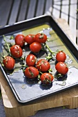 Tomatoes with herbs and olive oil on a baking tray