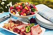 Cold cuts and fruit salad with feta, olives and basil