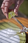 Rubbing glass rim with lime juice (for sugared or salted rim)