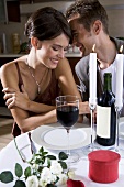 Young couple with red wine by candlelight
