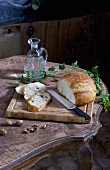 Partly sliced bread and nuts on rustic table