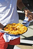 Person holding pan-cooked macaroni cheese