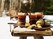 Hot Kentucky Toddies and biscuits on table in snowy garden