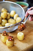 Stuffing new potatoes with salsa