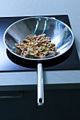 Coloured farfalle in a wok frying pan