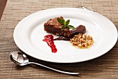 Chocolate nut cake with raspberry sauce and nuts