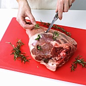 Studding a leg of lamb with rosemary