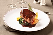 Pork fillet with jus on roast potatoes and spinach