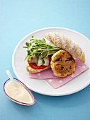 Fish cake and salad in bread roll, sauce