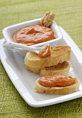Toasted baguette slices with red pepper spread