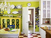 Table with salad, cabinet & shelves in a kitchen-living room