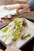 Preparing fish in salt coating: garnishing with dill