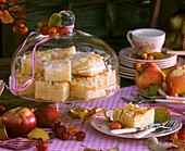 Apple cake under glass dome & on plate, apples, crab apples