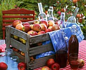 Obstkiste mit Äpfeln und Flaschen mit Saft