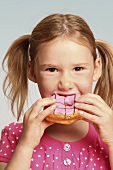 Girl eating an iced doughnut