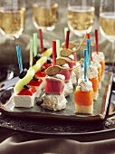 Fish & cheese on cocktail sticks, glasses of sparkling wine