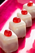 Punschkrapfen (small iced cakes) with cocktail cherries