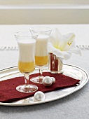 Two glasses of egg punch with pineapple on a silver tray
