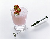 Strawberry shake with strawberry skewer, mini-whisk