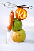Two apples, one orange, knife and whisk