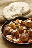 Meatballs with tomato sauce, apricots and flaked almonds