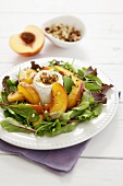 Salad leaves with peach slices, goat's cheese & walnut dressing