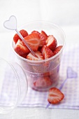 Fresh strawberries with cocktail stick in a plastic tub