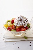 Fruit salad with cream & grated chocolate in glass dish