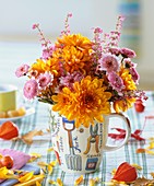 Chrysanthemums and bell heather in mug