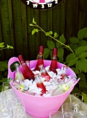 Rosé wine and various soft drinks in an ice bucket