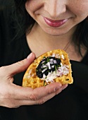 Waffle topped with sour cream and caviar