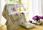 Bedspread and book on bench, peonies and juice on tray