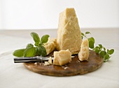 Parmesan with basil on wooden board