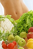 Gemüse und Obst vor nacktem Bauch