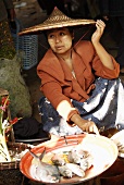 Asian woman selling fish