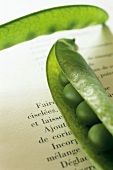 Pea pods on the page of a book
