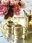 Silver teaset and vase of flowers