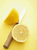 Eine halbierte Zitrone mit Messer