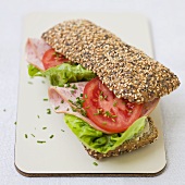 Sliced sausage, lettuce and tomato in wholemeal roll