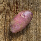 A purple potato on a wooden background