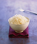 Rice in white bowl on blue background