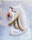 Raw sausages in parchment paper