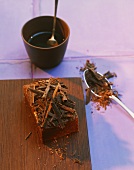 Brownie mit Raspelschokolade auf Holzbrett