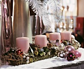 Adventsgesteck mit vier rosa Stumpenkerzen
